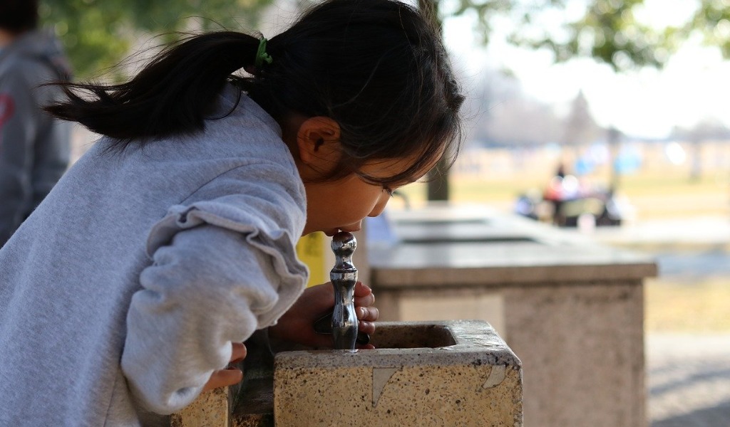 公園で水を飲む子供の画像です。